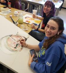 Two students painting in a classroom