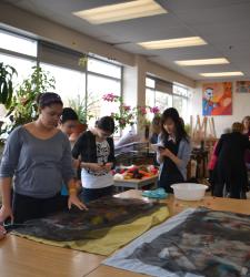 Students talking and working in an art classroom