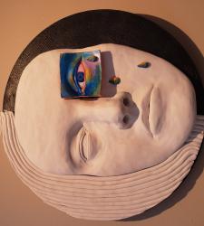 A clay portrait with one colourful and crying eye
